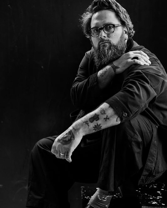Grégoire Gerstmans poseert zwartwit met zijn tattoos